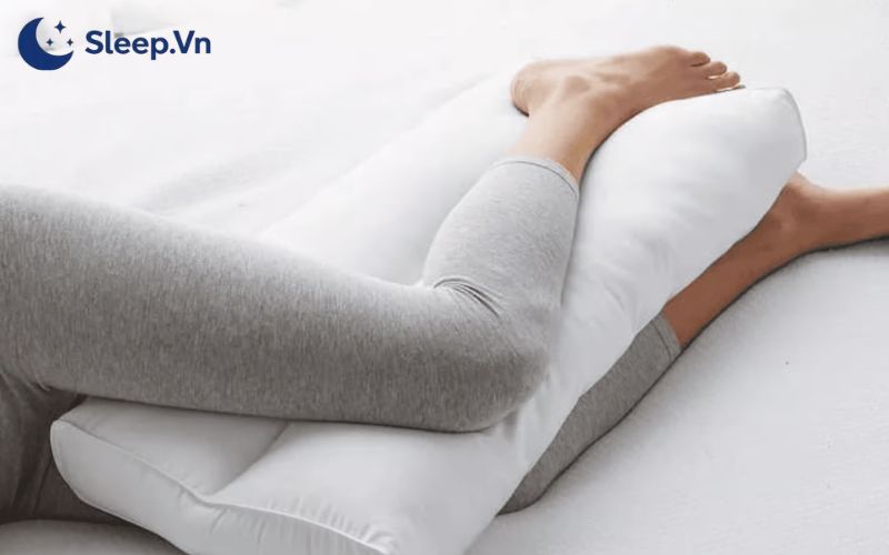Tư thế ngủ nói lên điều gì? Giải mã thói quen và tính cách 6 Kẹp một chiếc gối giữa 2 đầu gối khi nằm nghiêng